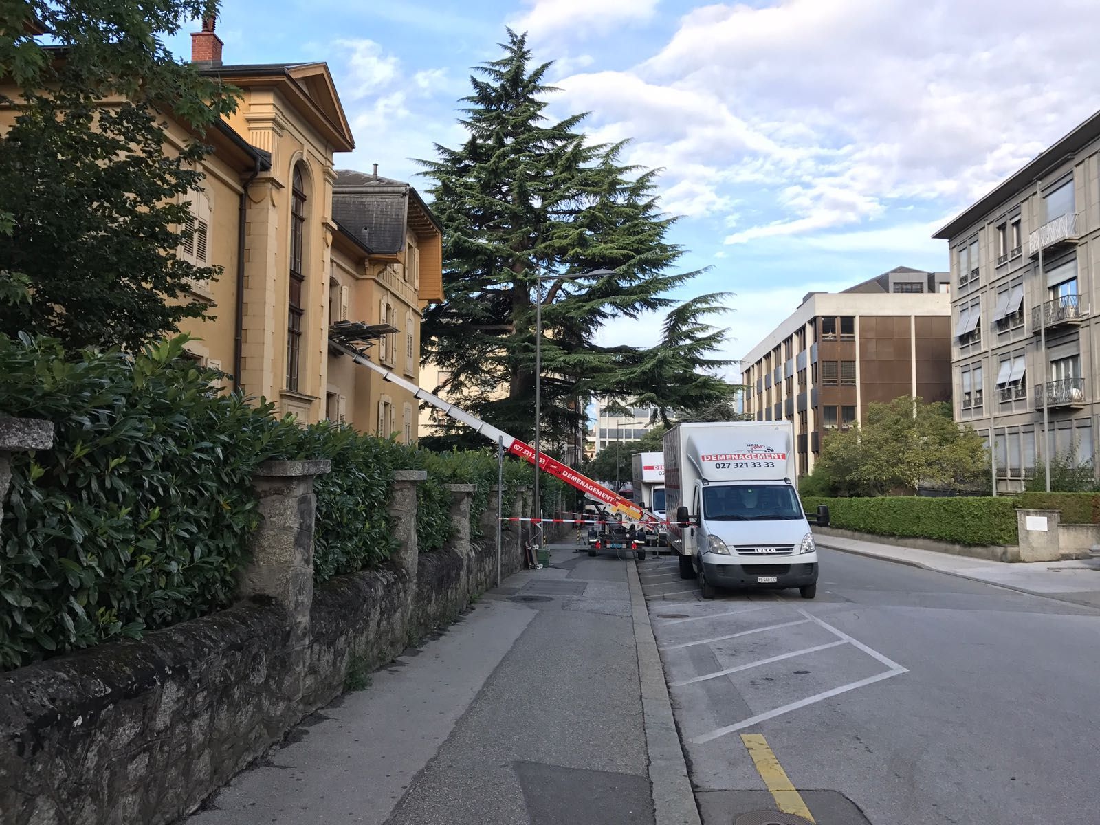 Une camionnette blanche est garée sur le bord de la route pour un déménagement en ville