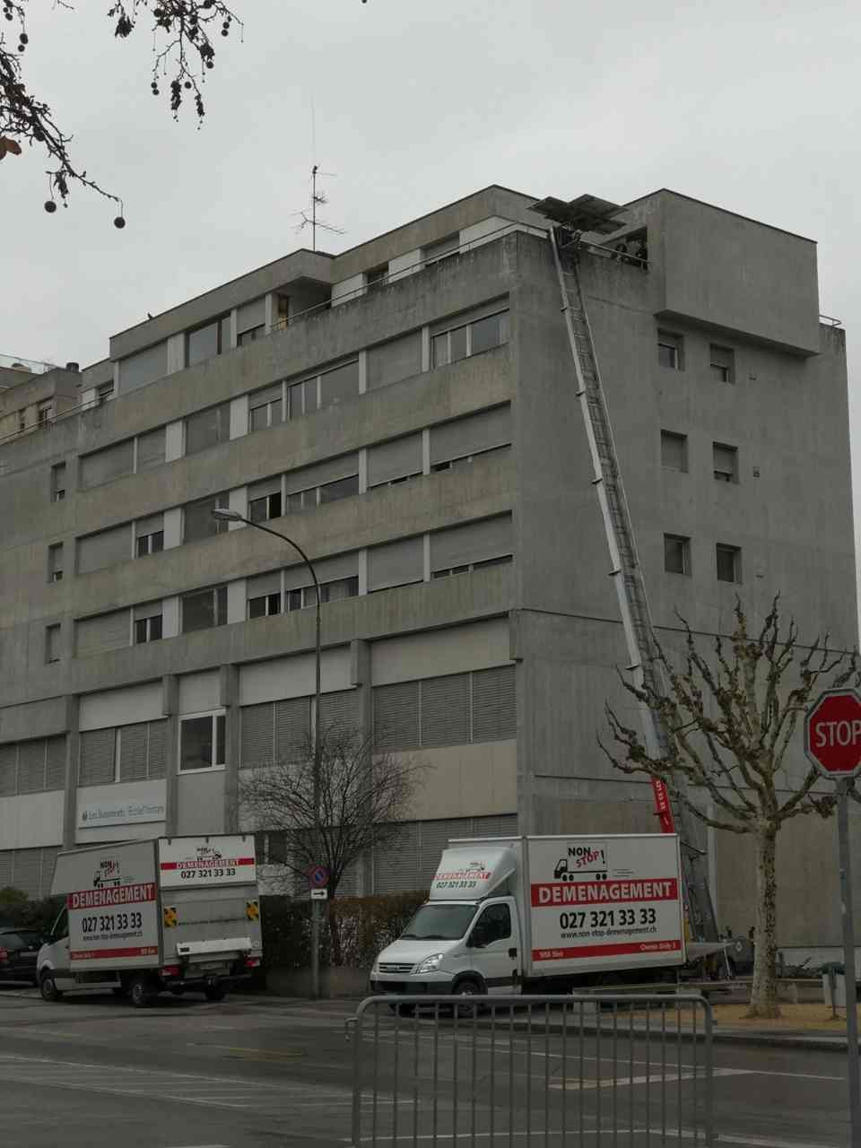 Un panneau d'arrêt se trouve devant un grand bâtiment