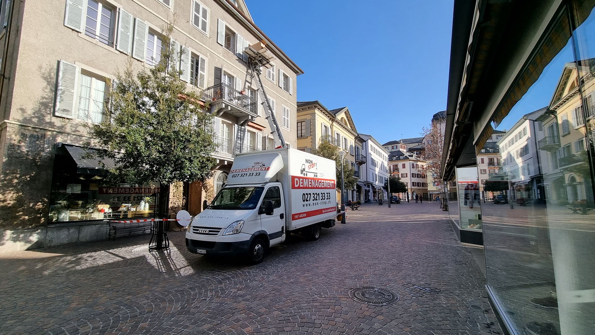 Une camionnette blanche est garée au milieu d'une rue de la ville.