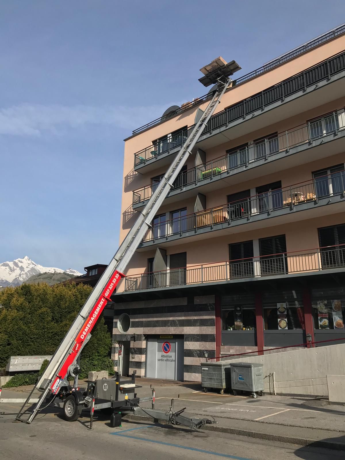 Un grand bâtiment avec une grue sur le côté.