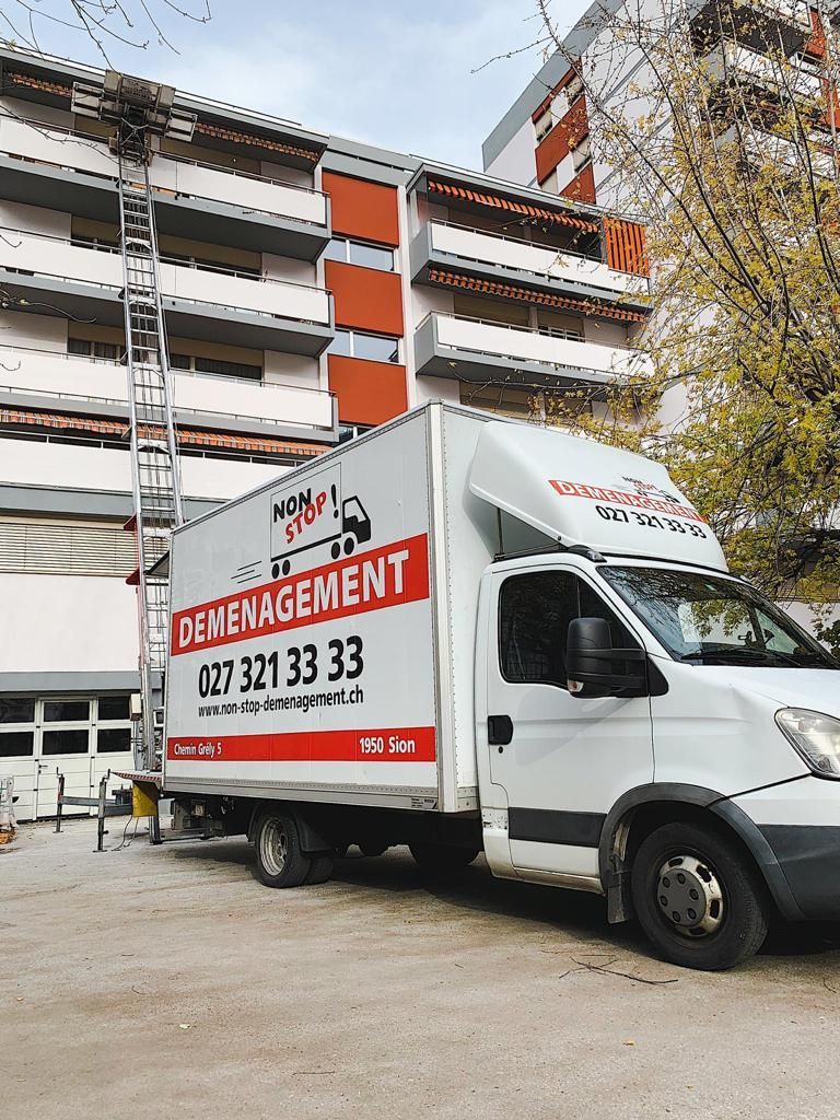Un camion de déménagement est garé devant un immeuble.