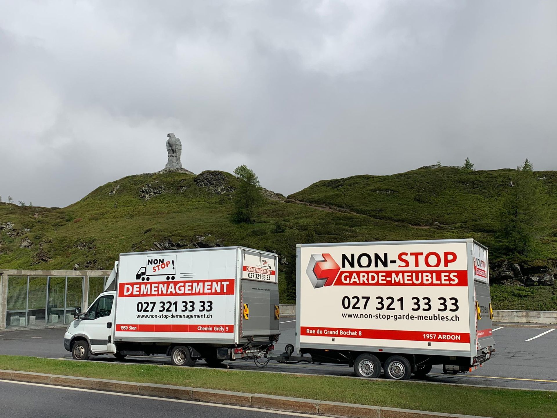 Deux camions de déménagement sont garés l'un à côté de l'autre sur le bord de la route.