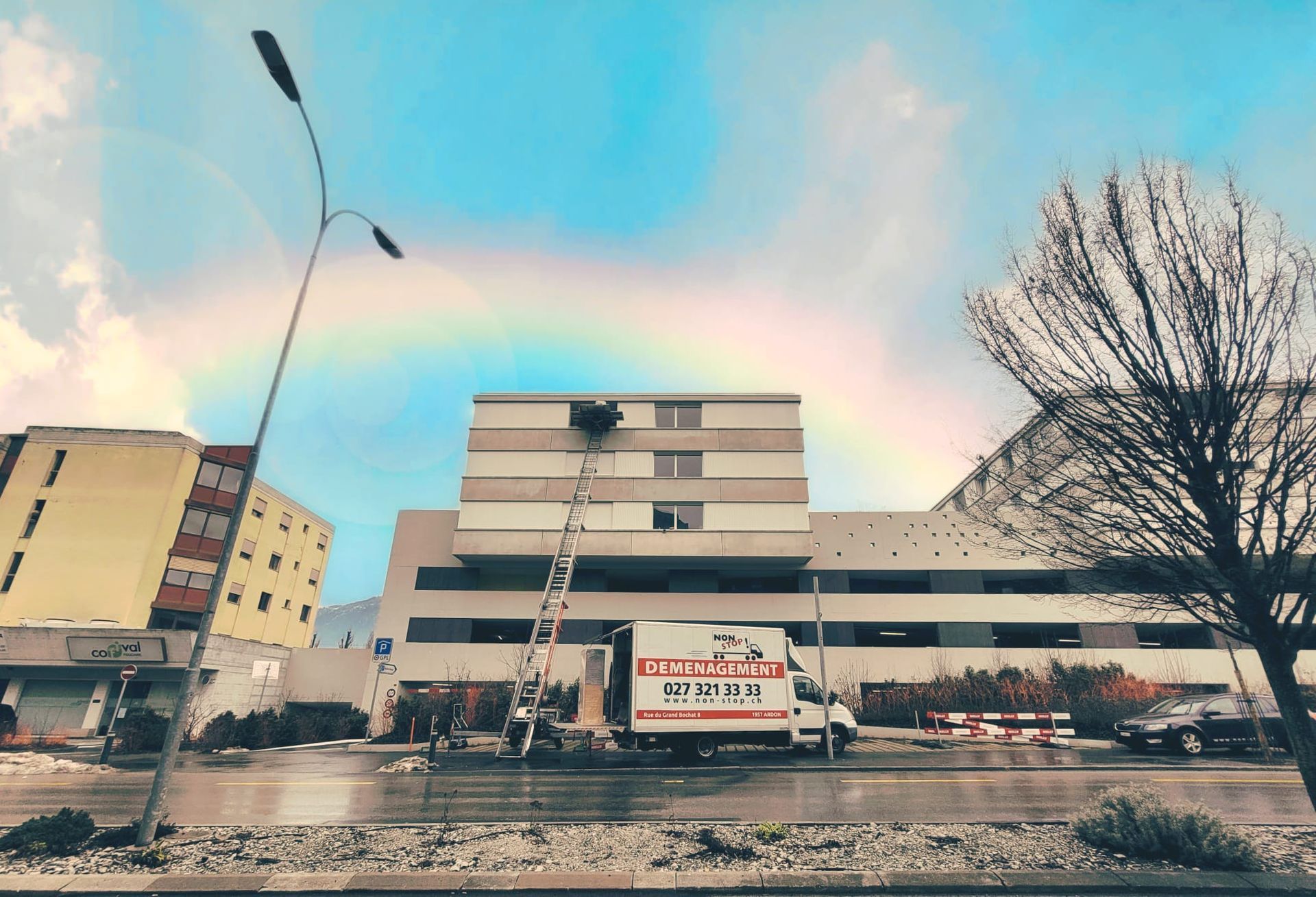 Un grand bâtiment avec une camionnette blanche garée devant