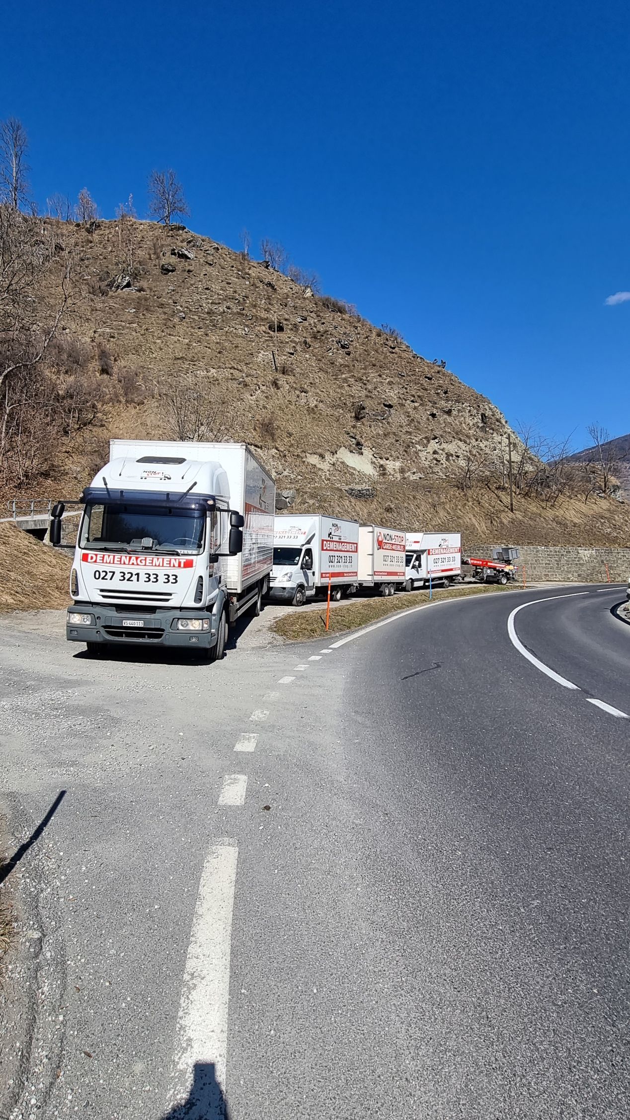 Une rangée de camions est garée au bord d'une route.