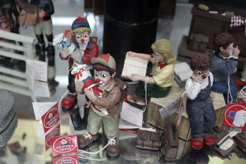 Eine Gruppe von Clownfiguren sitzt auf einem Tisch.