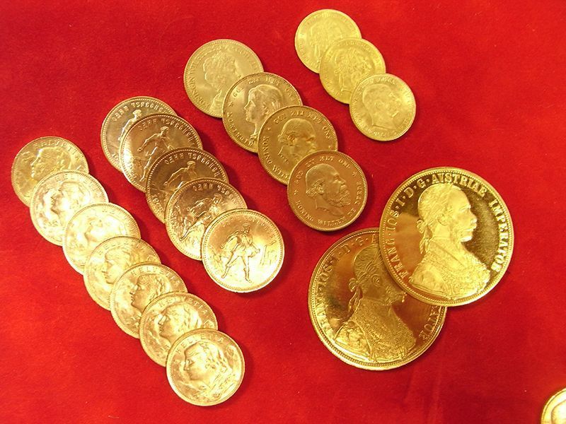 Ein Haufen Goldmünzen sind auf einer roten Fläche aufgereiht