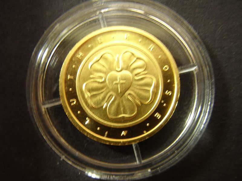 Eine Goldmünze mit einem Herz und einem Kreuz darauf