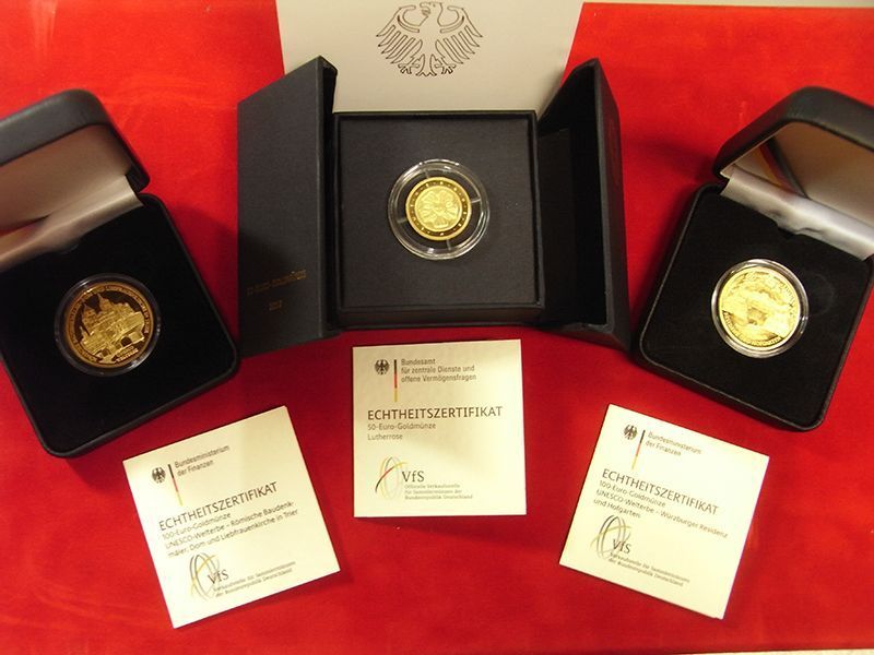 Zwei Goldmünzen in schwarzen Boxen mit Zertifikat