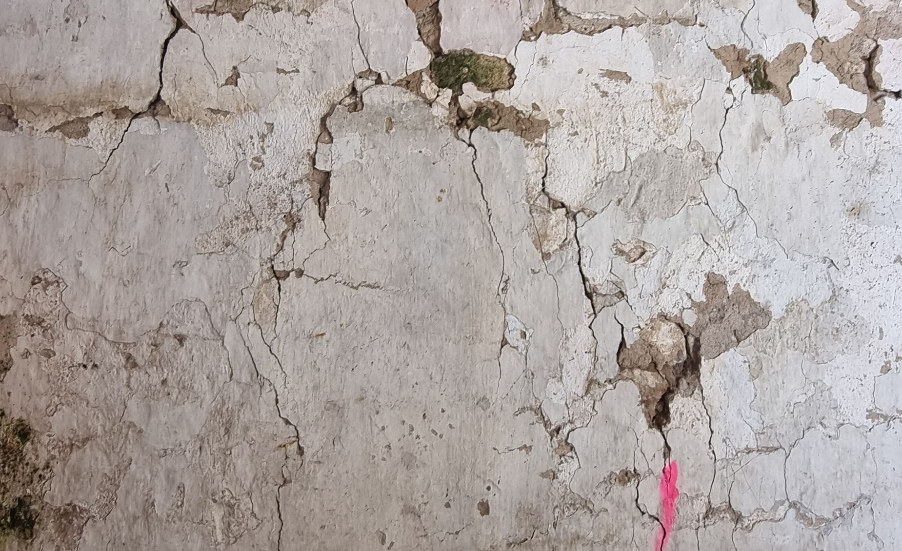 Des fissures sur un mur comprenant une marque de couleur rose