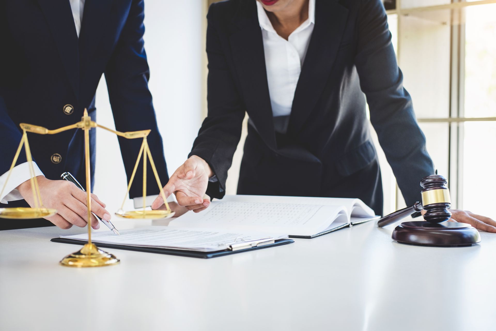 Des personnes sur un document posé sur un bureau.