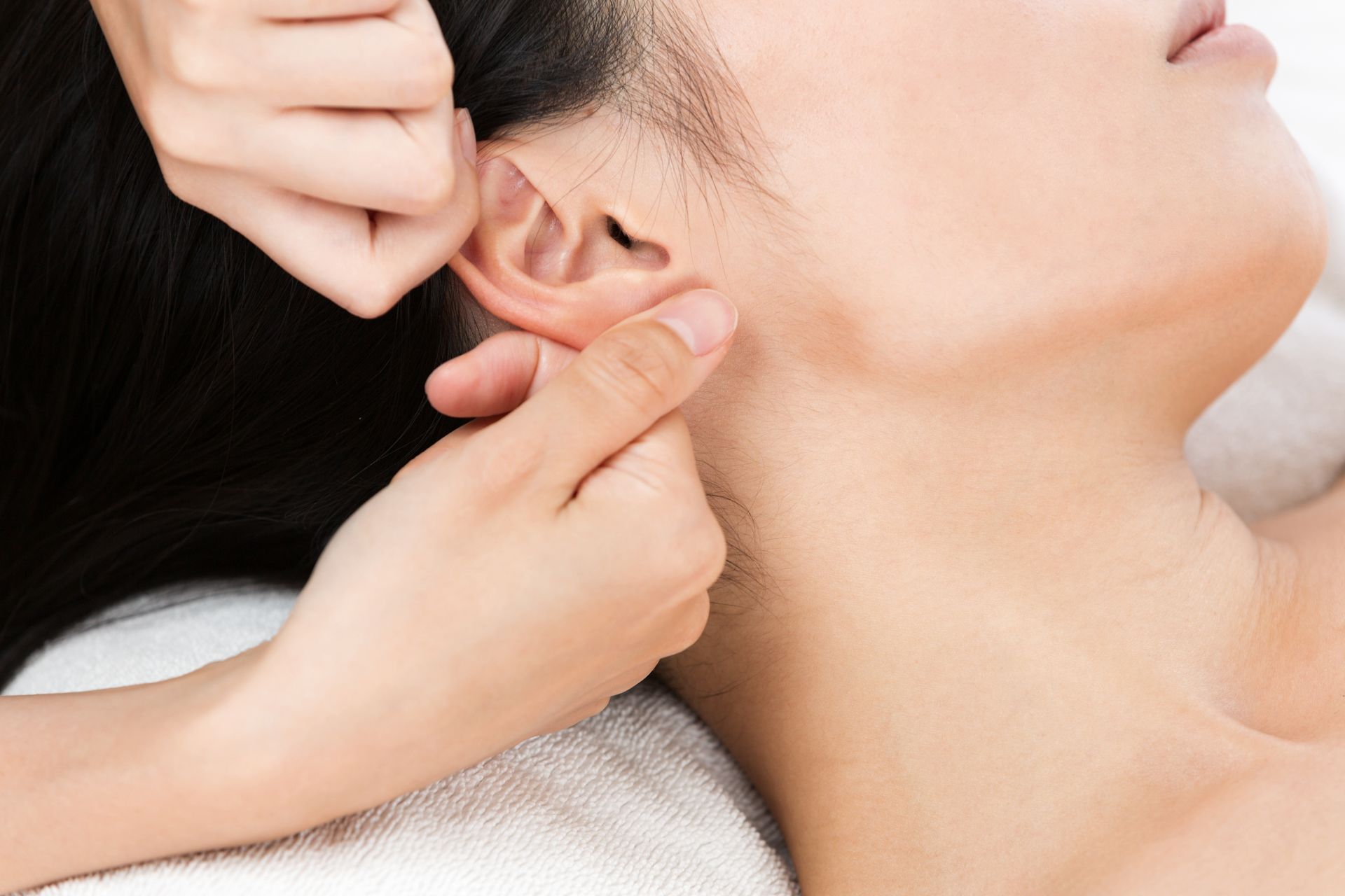 Une femme reçoit un traitement d'acupuncture sur son oreille.