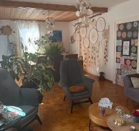 Un salon rempli de meubles et un attrape-rêves sur le mur.