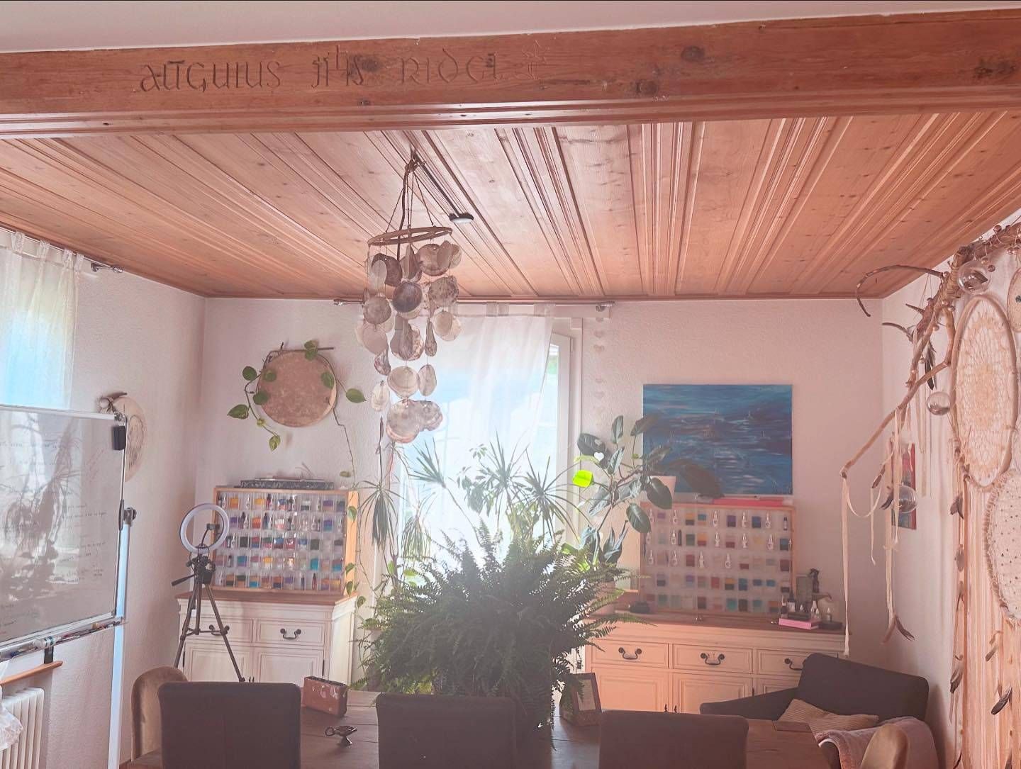 Un salon avec un plafond en bois et un tableau au mur.