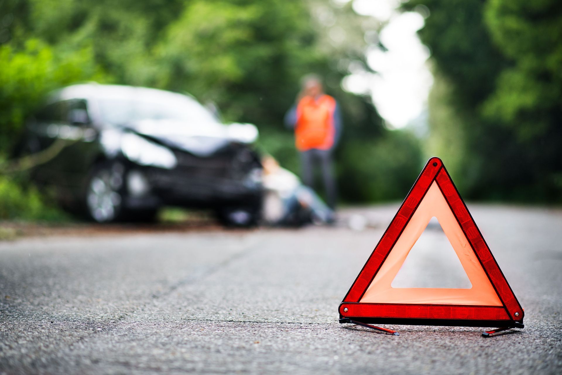 Triangle rouge près d'une voiture accidentée