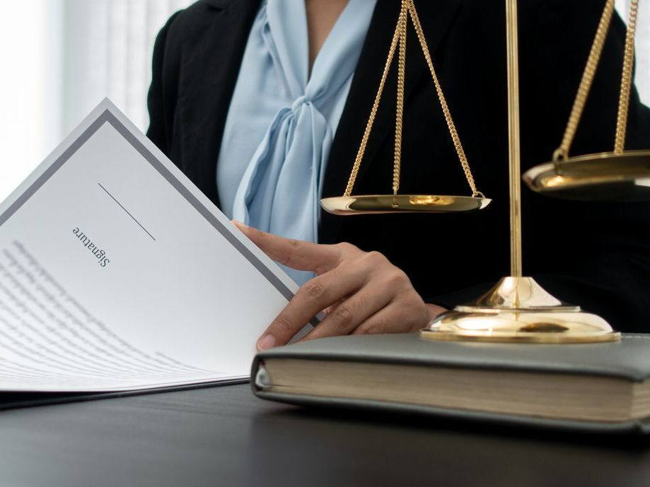 Femme lisant un document avec une balance de la justice à côté d'elle