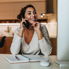 Une femme souriante au téléphone.
