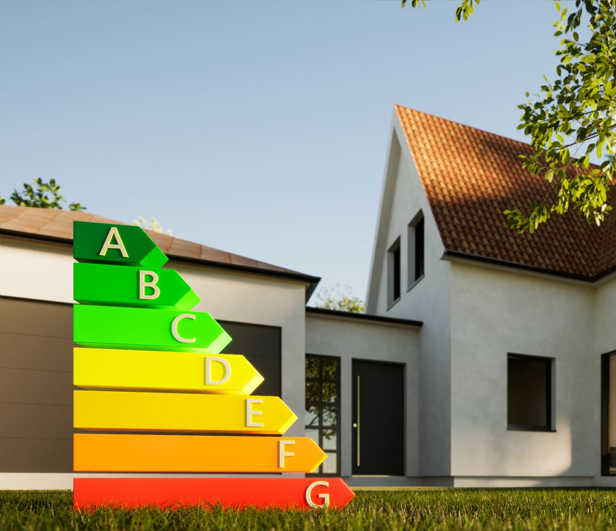 Une échelle de notation énergétique multicolore allant de A à G devant une maison.