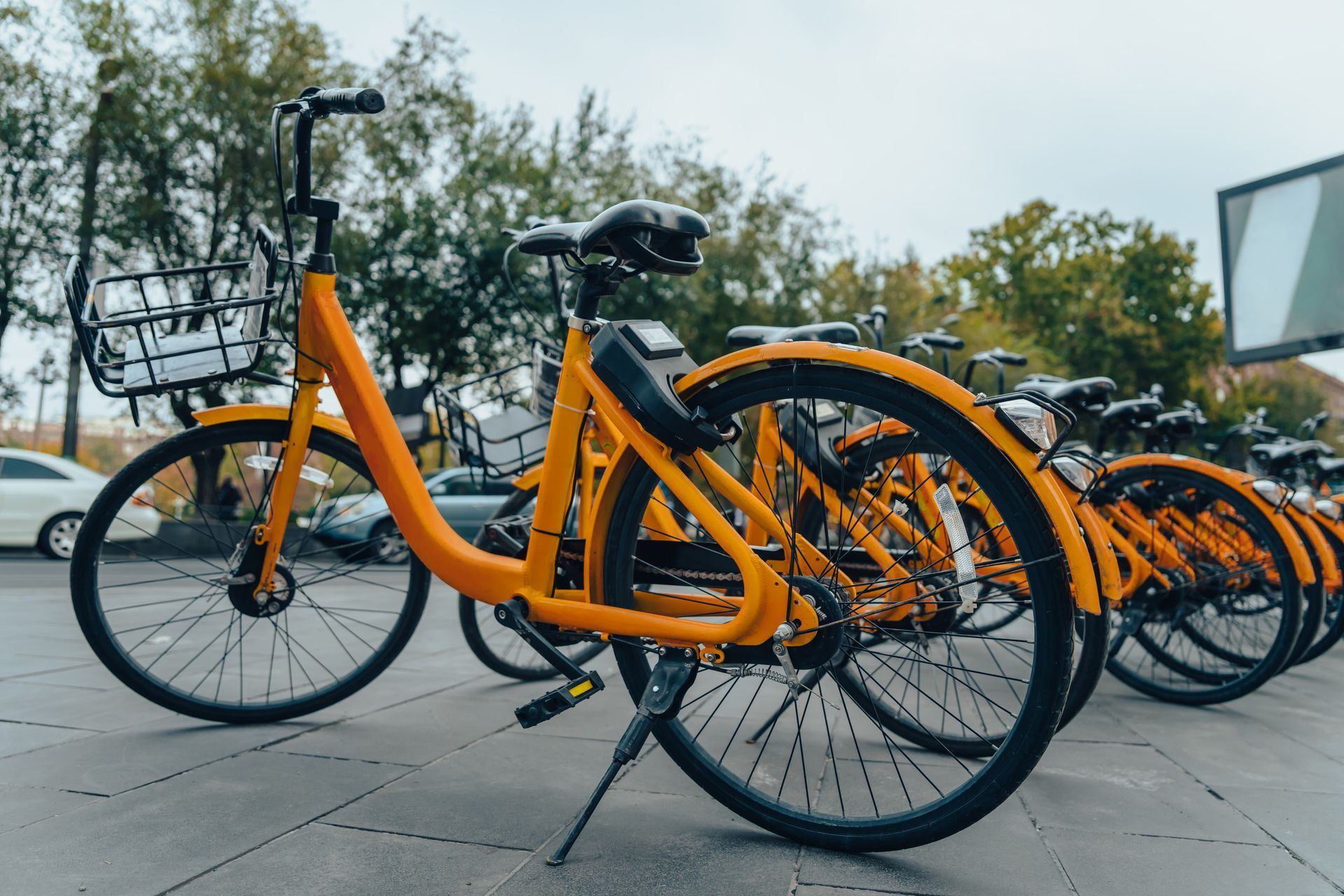 Bicicletas de alquiler amarillas estacionadas en fila en una acera de la ciudad.