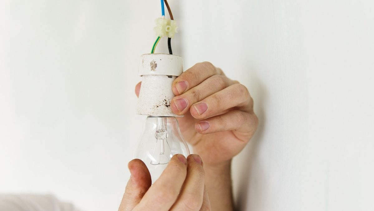 Una persona sostiene una bombilla en sus manos.