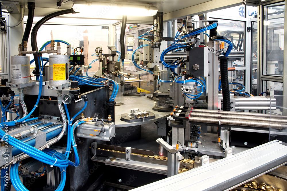 Bracci robotici che assemblano schede di circuiti stampati in fabbrica.