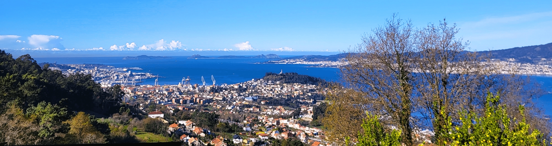 Una vista de una ciudad desde una colina con vistas al océano.
