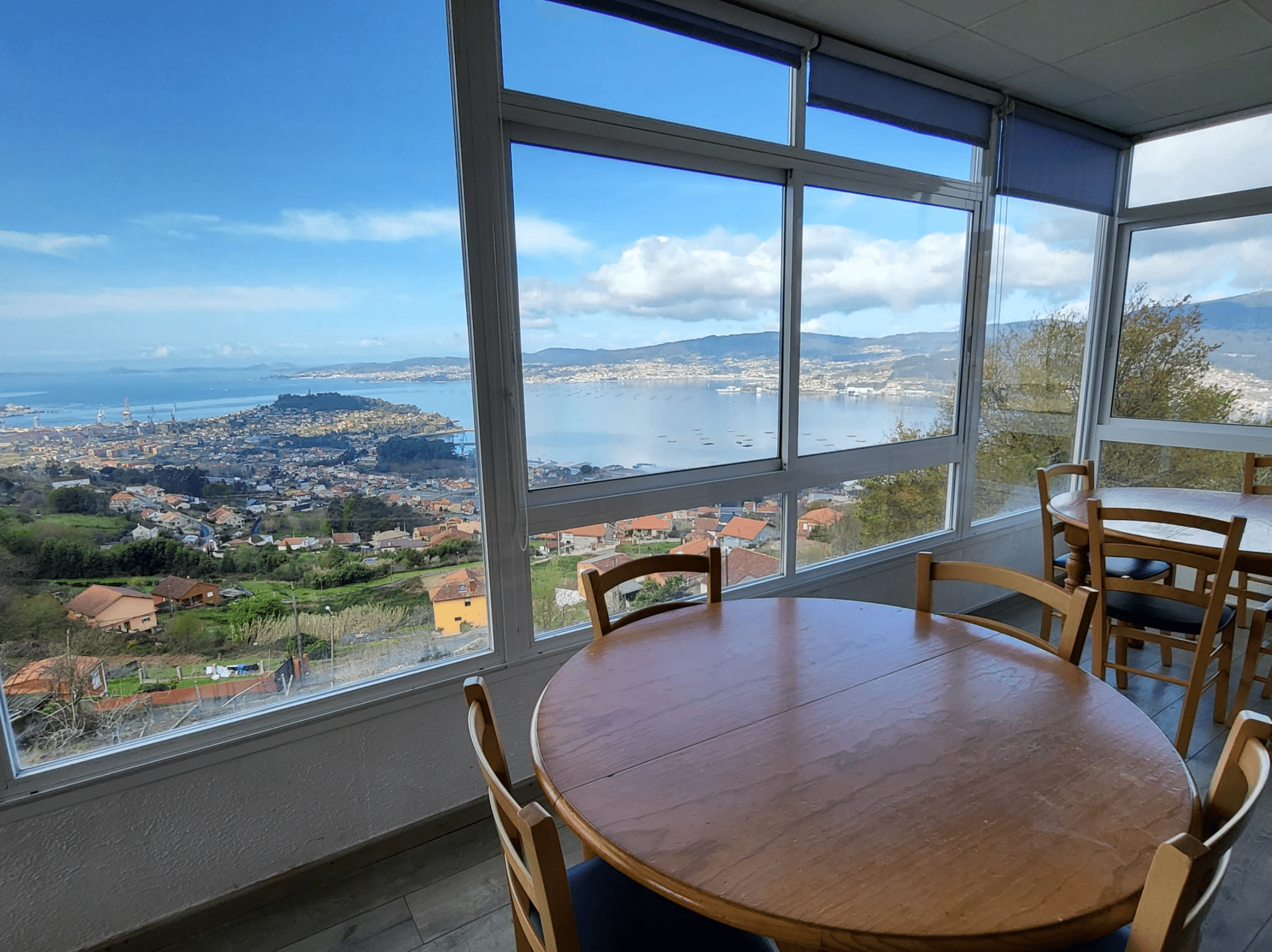 Un comedor con mesa y sillas y vista al mar.