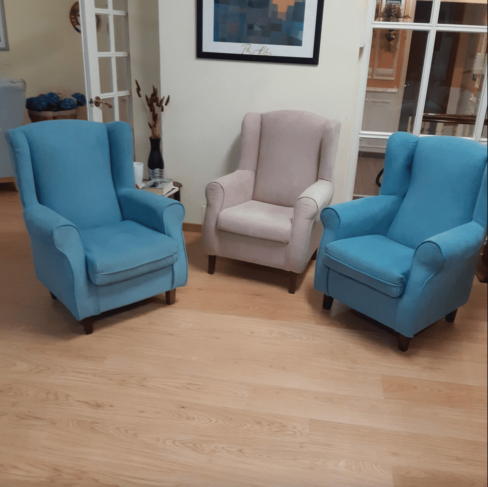 Tres sillas azules y blancas están sentadas en una sala de estar.