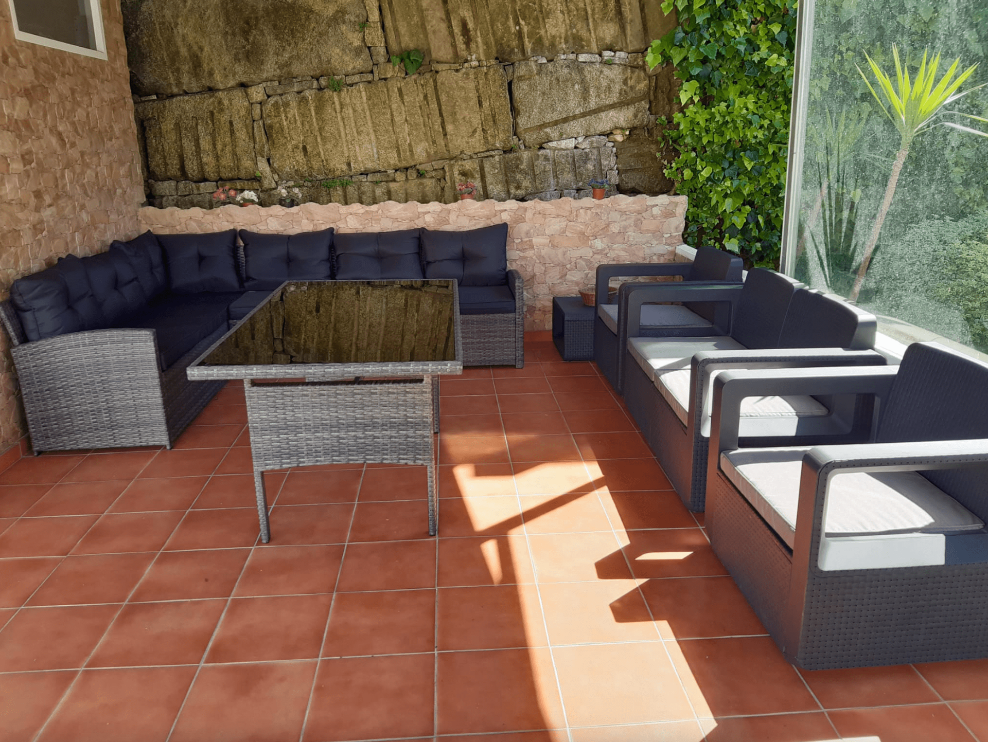 Un patio con un sofá y sillas y una mesa.