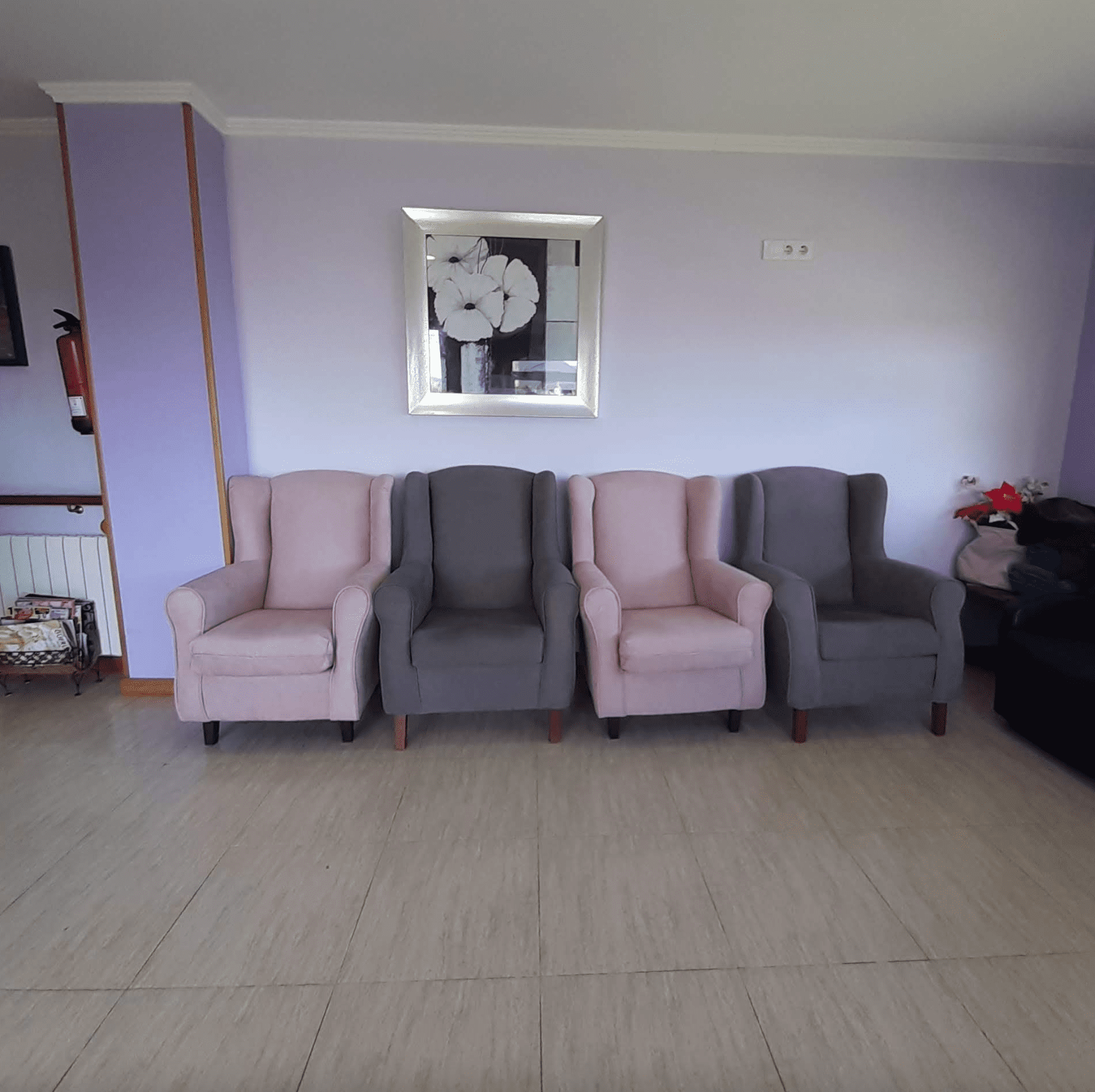 Cuatro sillas están alineadas en una habitación con paredes moradas.