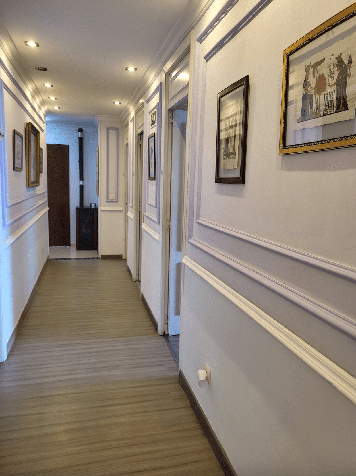Un largo pasillo con muchos cuadros en la pared.