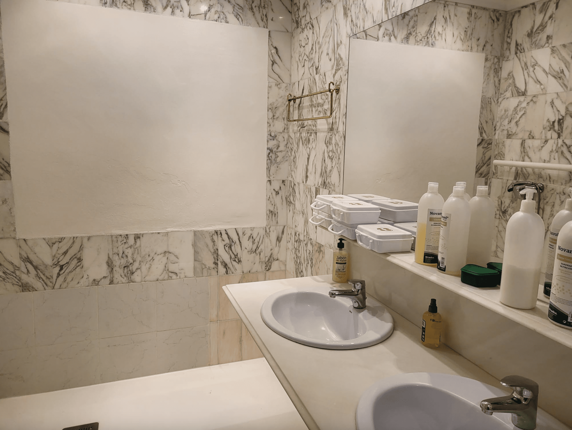 Un baño con dos lavabos y un espejo.