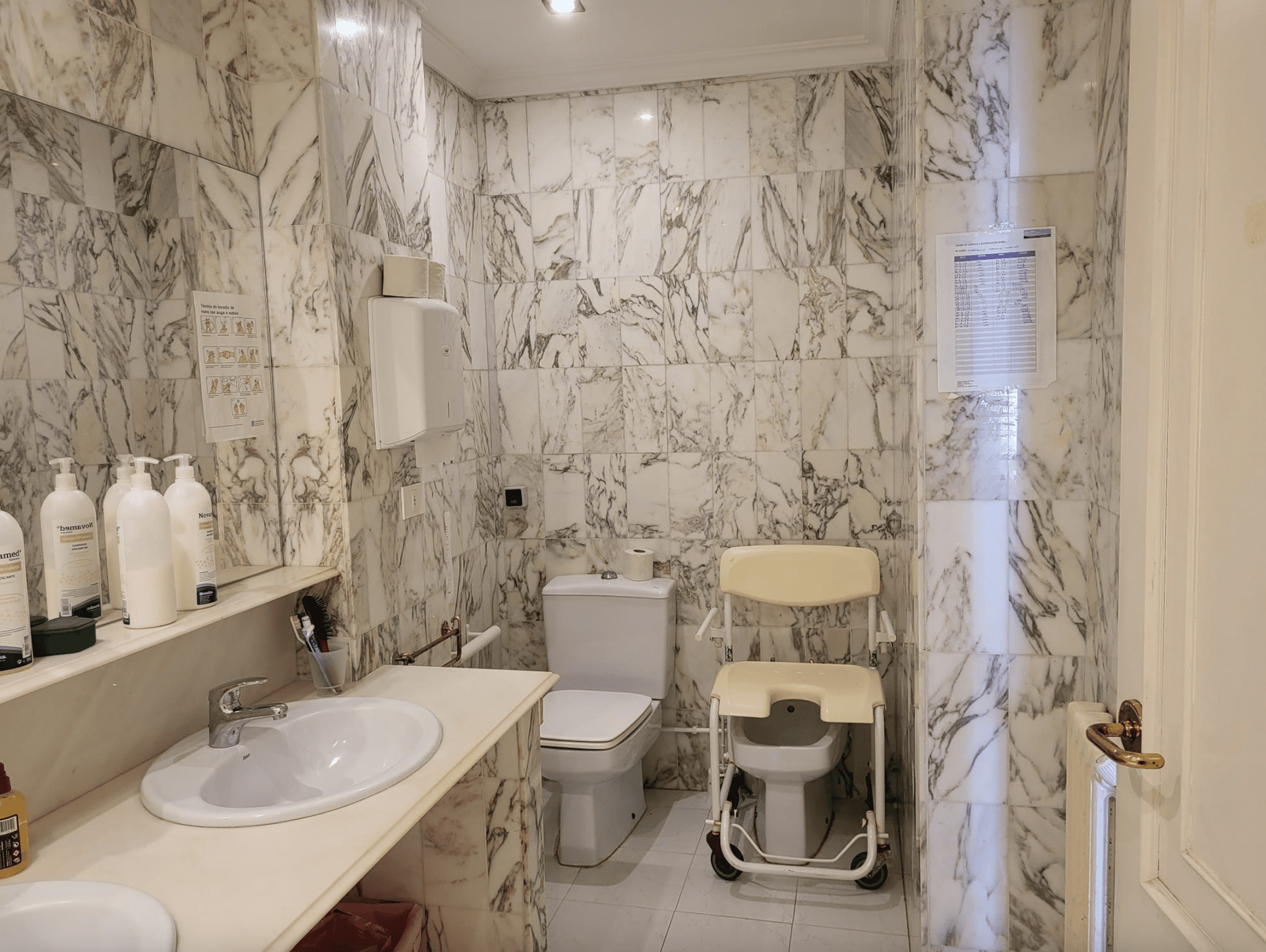 Un baño con inodoro, lavabo y silla.