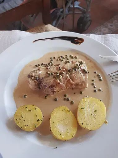 Un plato de comida con patatas y salsa sobre una mesa.