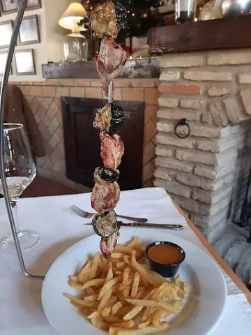 Un plato de comida con patatas fritas y salsa sobre una mesa.