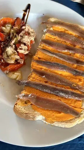 Un plato blanco cubierto con un sándwich y una ensalada.