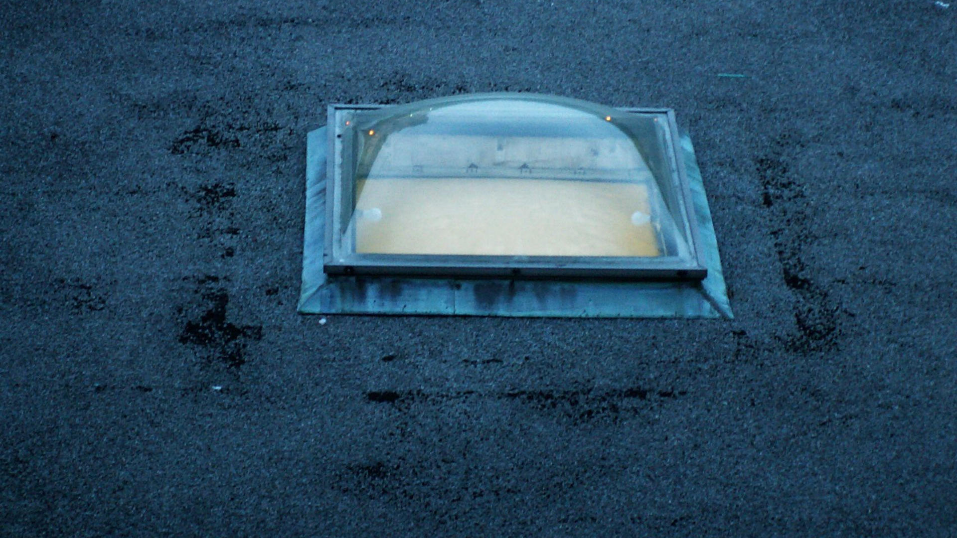 Puits de lumière sur un toit sombre.