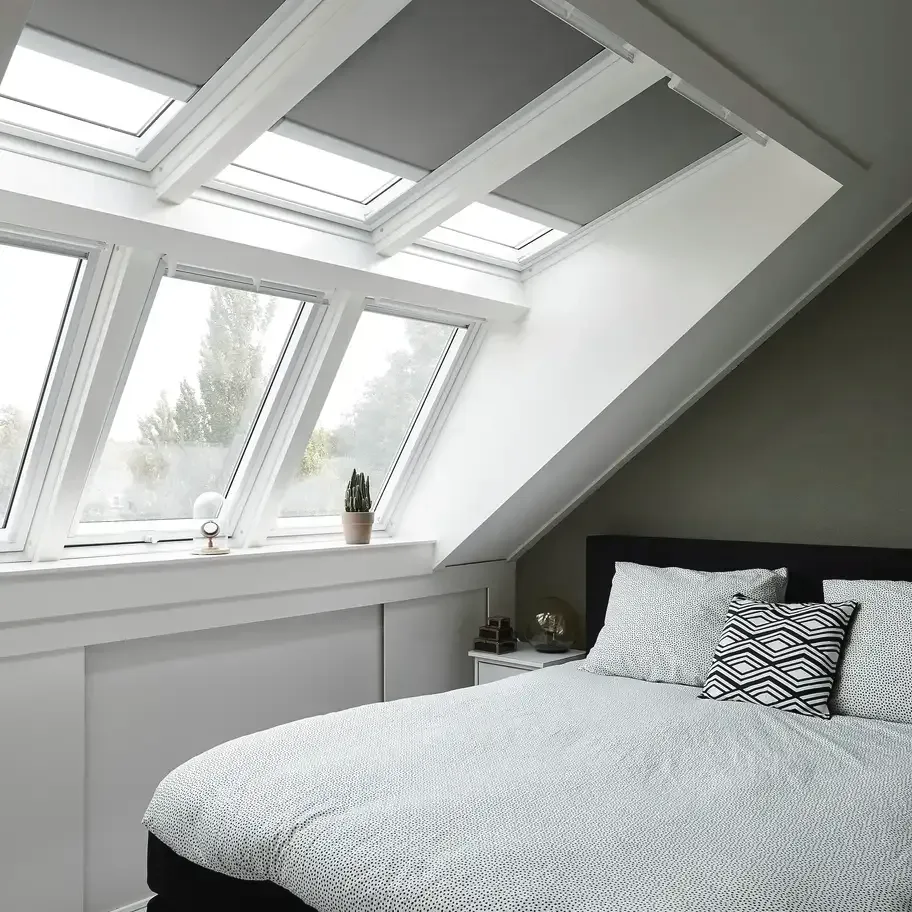 Chambre avec plafond en pente et verrière.