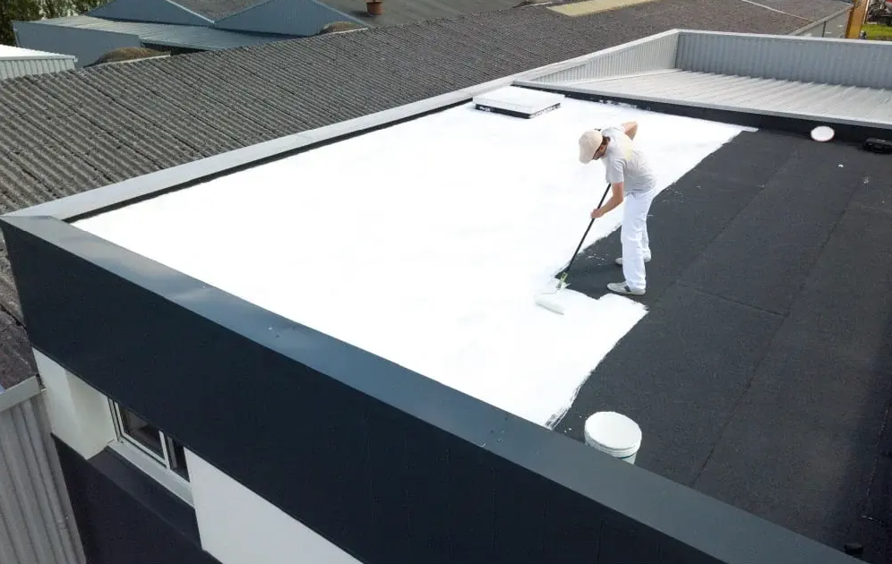 Un homme effectue de l'isolation de toit plat par Cool Roof