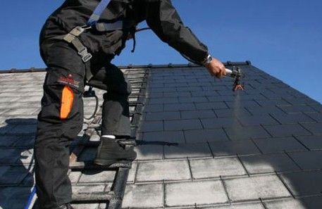 Un homme utilise un dispositif de nettoyage de toiture