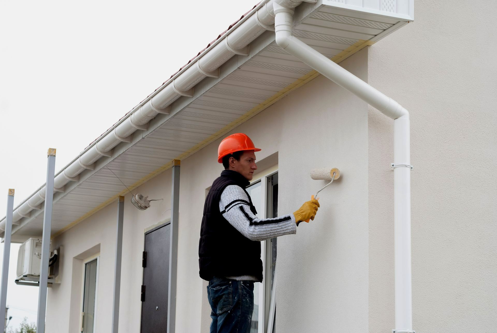 Un artisan peintre peint un mur