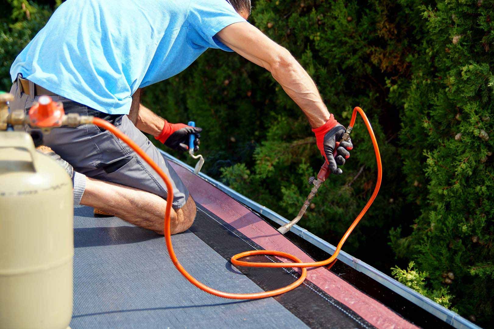 Un homme effectue des travaux d'étanchéité de toit