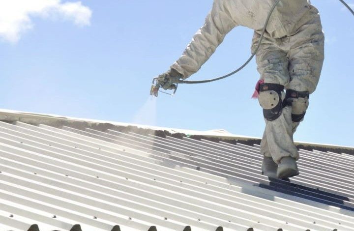 Un couvreur peint une toiture
