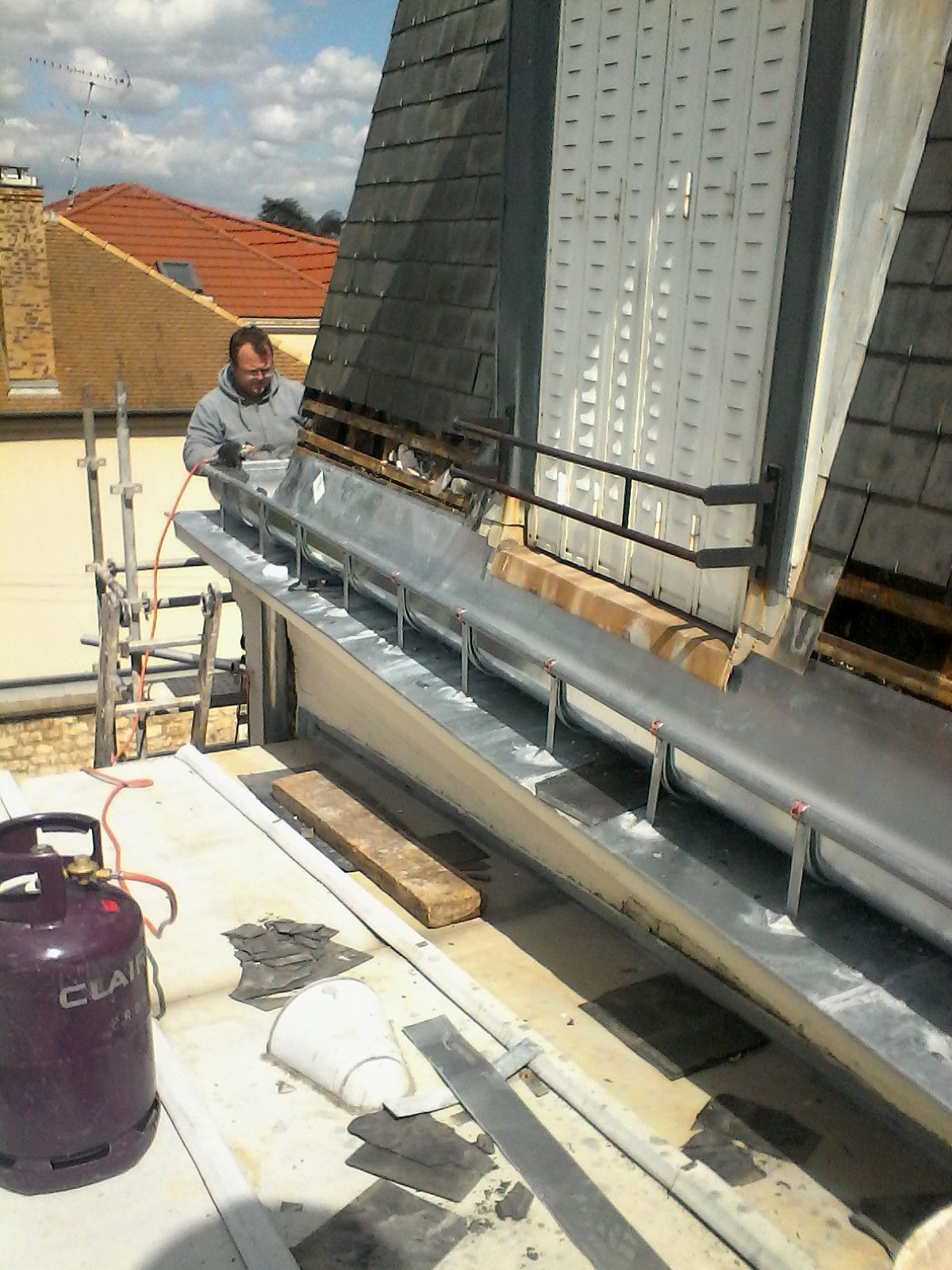 Un homme installe de la zinguerie