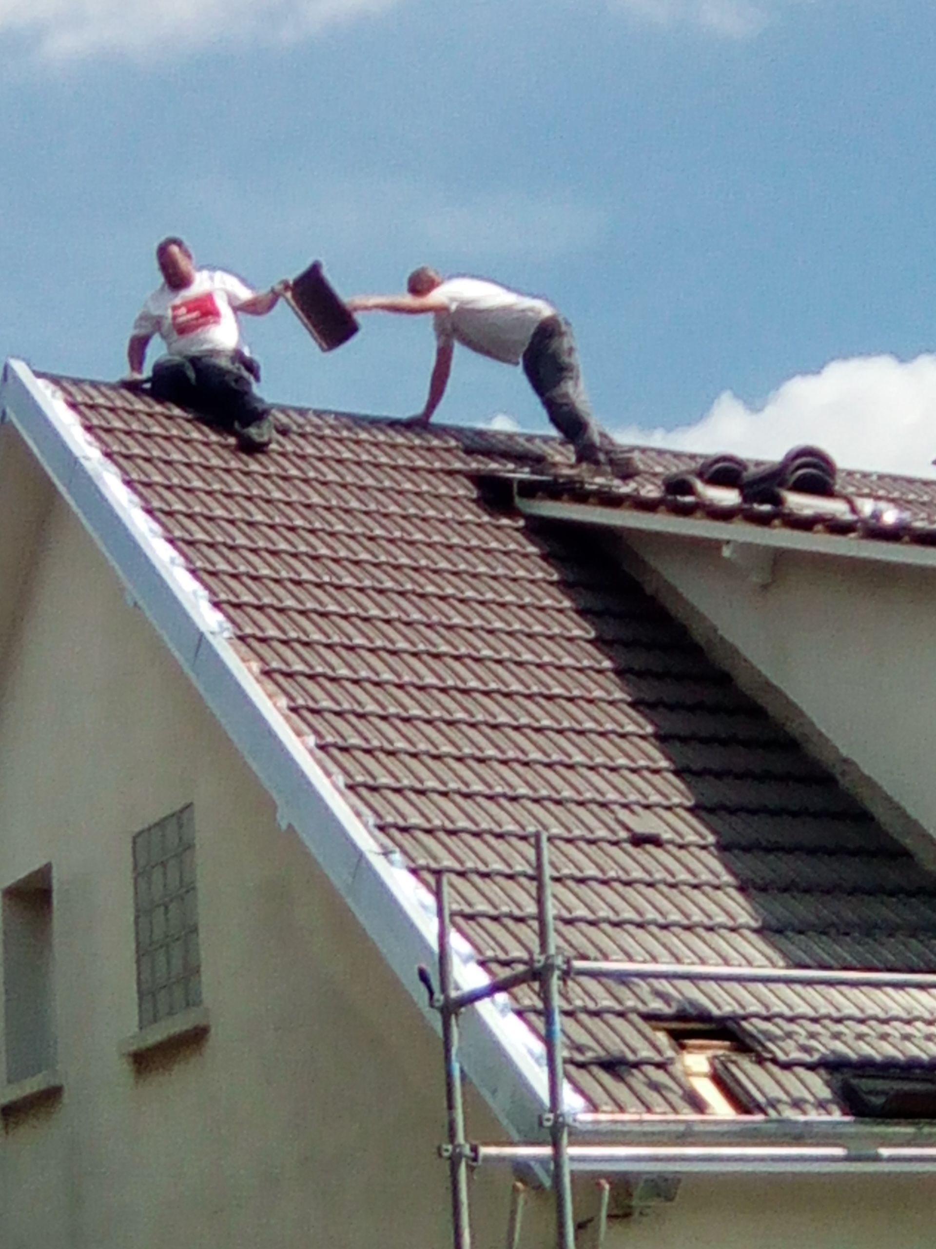 Deux artisans sur un toit en tuiles