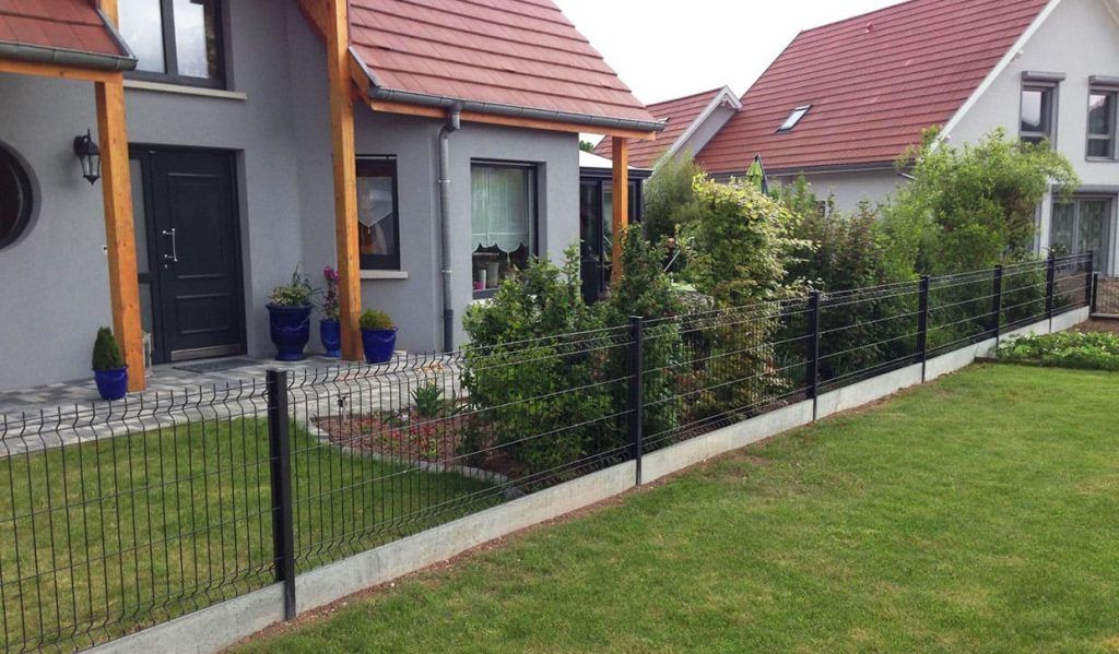 Clôture métallique noire discrète installée devant un pavillon neuf délimitant les propriétés sur le gazon