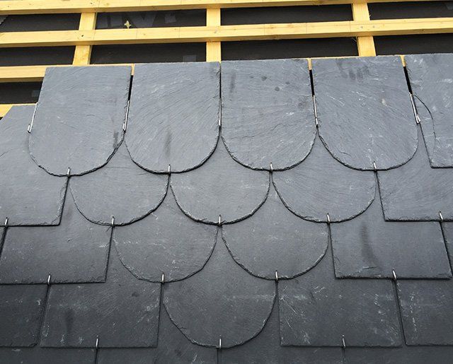 Toiture recouverte de tuiles en ardoise en cours de pose par la société Noirot Toiture
