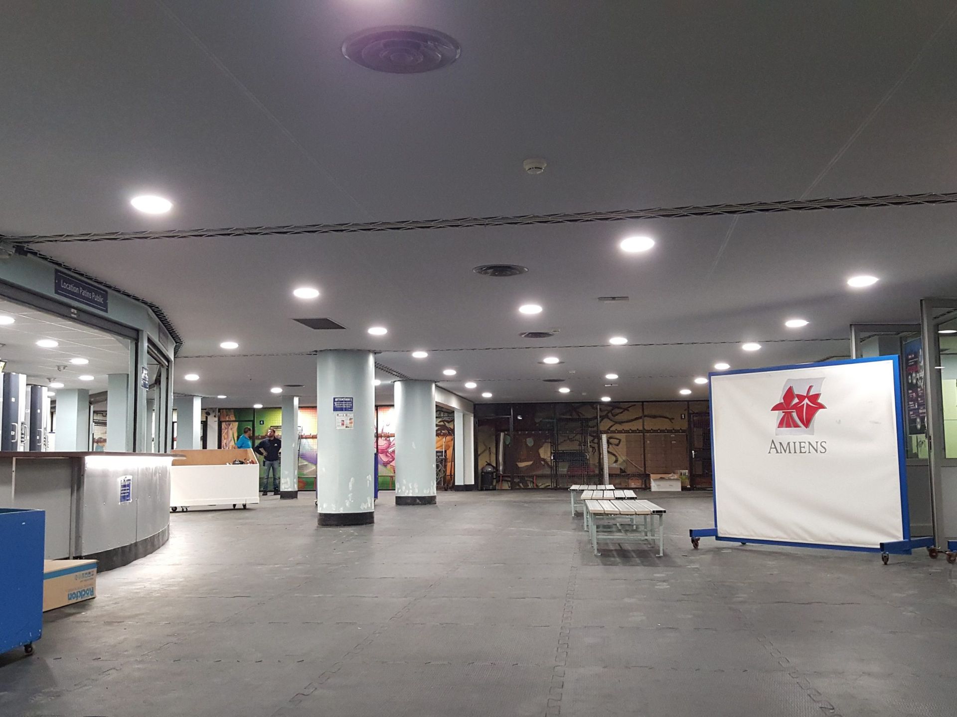 Intérieur vide avec des colonnes, des lumières vives et une membrane textile.