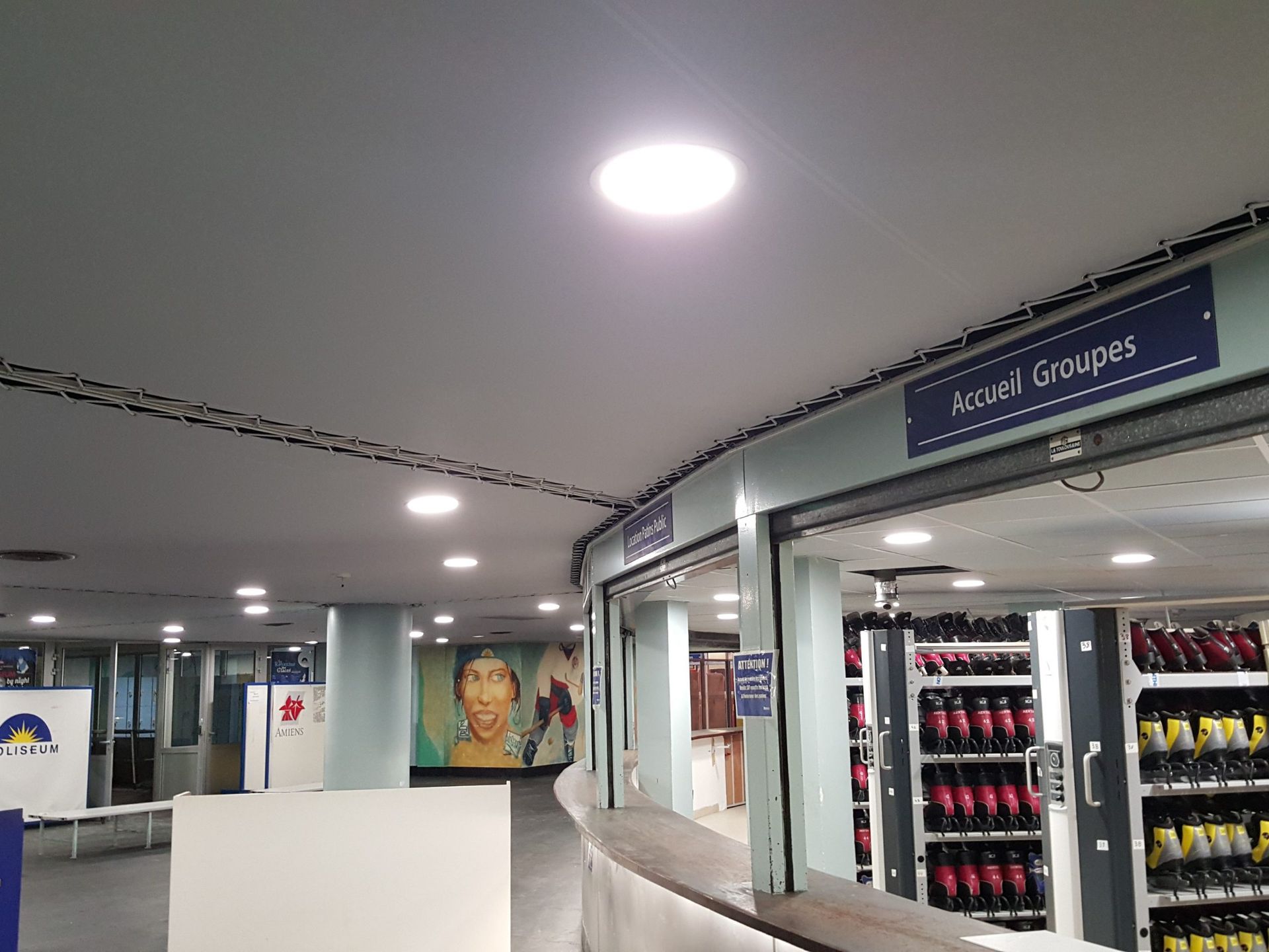 Comptoir d'accueil. Étagères de patins à roulettes en arrière-plan. Éclairage fluorescent.
