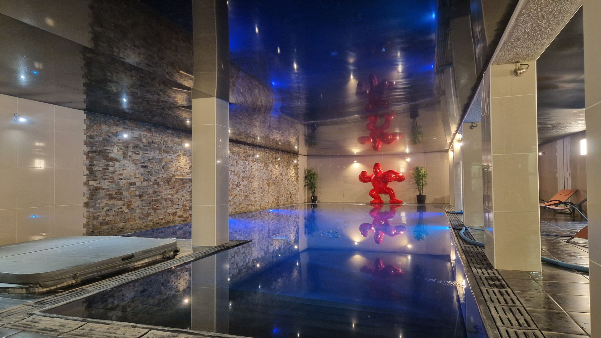 Un plafond avec des lumières horizontales lumineuses est installé dans une pièce inachevée avec des briques et des échelles.