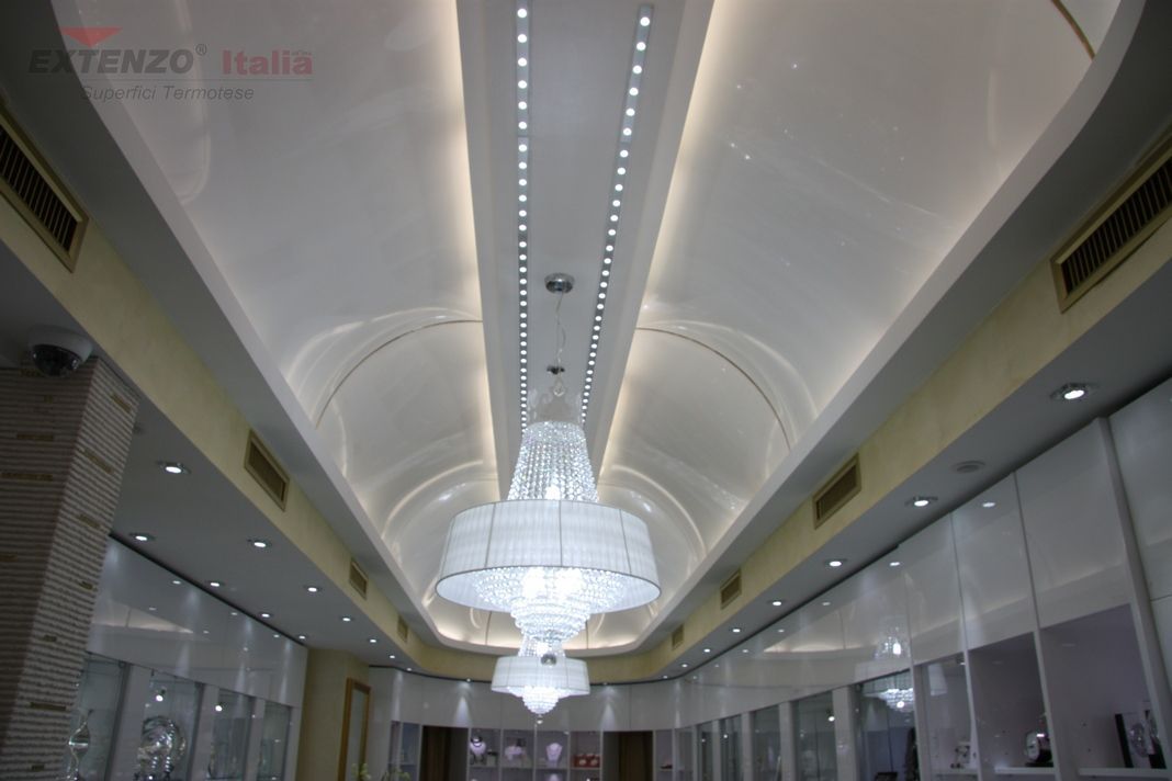Plafond orné avec lustres, éclairage encastré et présentoirs de vente au détail.